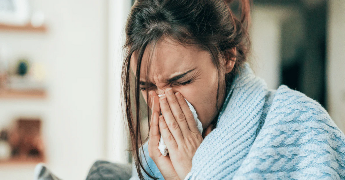 A woman enjoying fresh air during a seasonal change, symbolizing strong immunity and well-being with the help of NutraStore Immunity Booster.